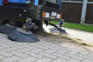 Balayeuse mécanique nettoyant une chaussée pavée