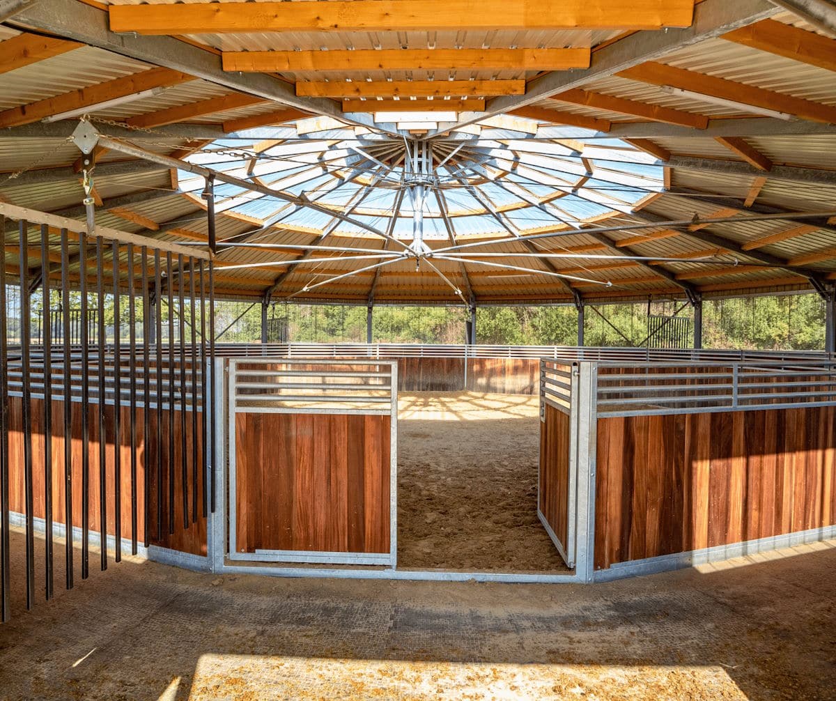 Intérieur d’écurie circulaire avec boxes en bois